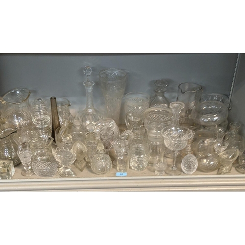 68 - A mixed lot of glassware to include a smoked glass jug, crystal cut decanters, a pair of cube style ... 