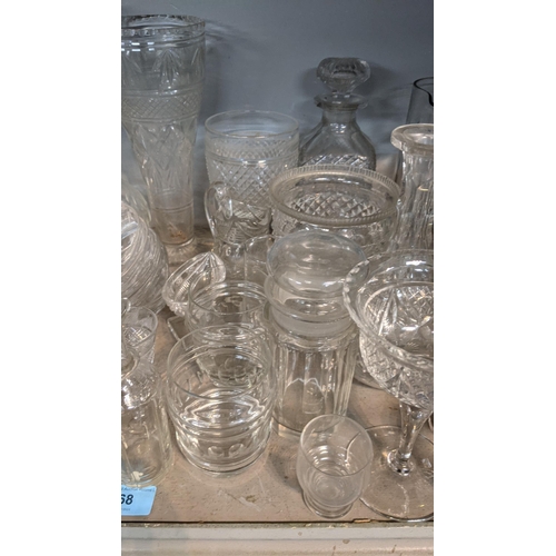 68 - A mixed lot of glassware to include a smoked glass jug, crystal cut decanters, a pair of cube style ... 