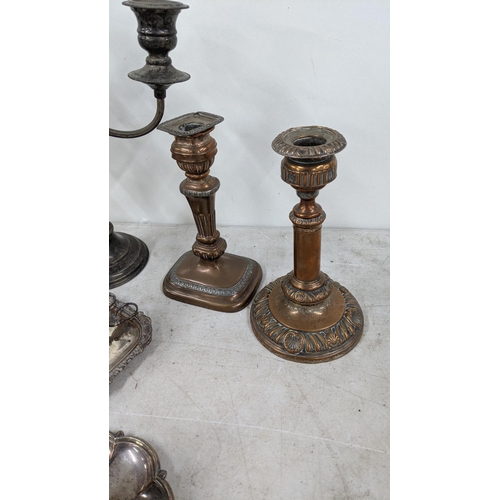 83 - A three branch candelabra, silver on copper plated together with a pair of candlestick holders along... 