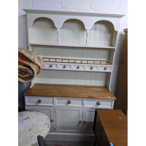 285 - A white painted pine dresser, the top with stepped cornice supported by turned columns above an arch... 