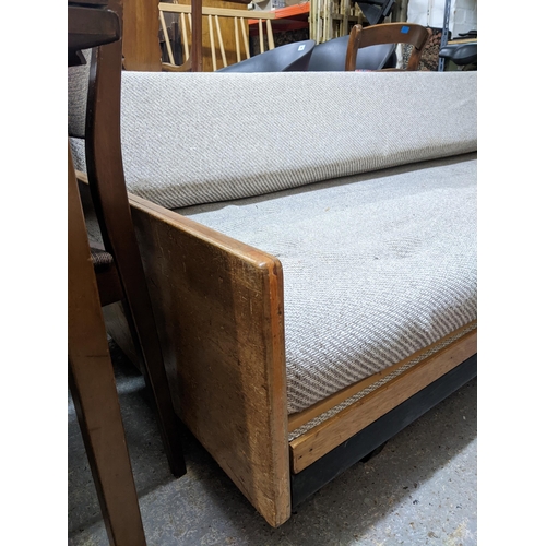 287 - Robin Day for Halle oak framed sofa bed, the arms inset with walnut, upholstered seat and swivel bac... 