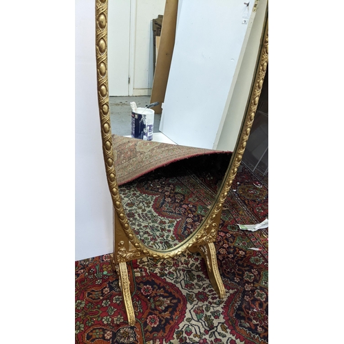 273 - A French style oval gold painted cheval mirror, the frame with egg and dart decoration, surmounted w... 