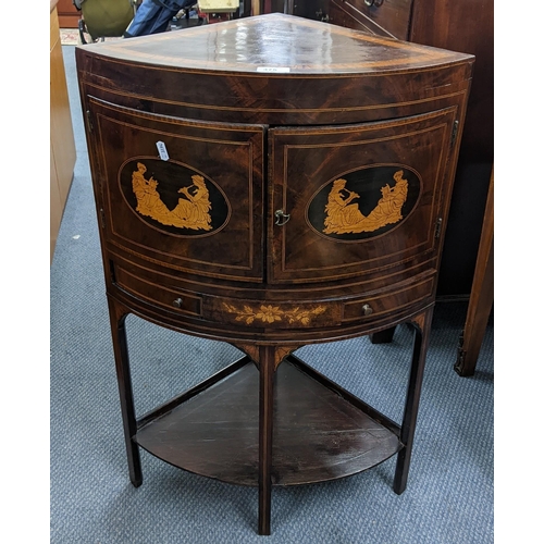 375 - An Edwardian mahogany corner table having a bow front and the doors with marquetry inlaid with class... 