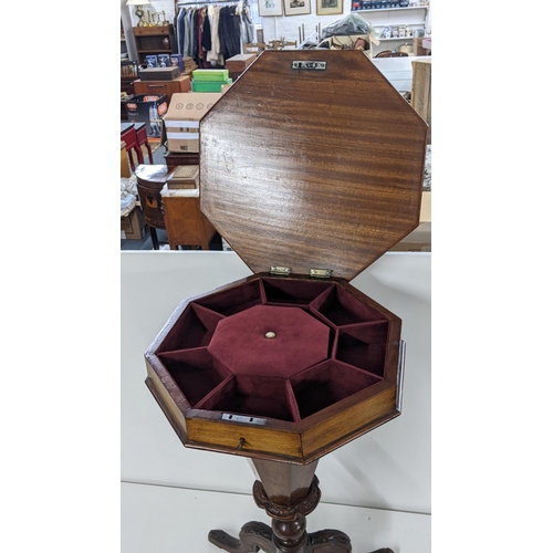 380 - A Victorian walnut sewing table having a hinged octagonal top with a fitted interior and tripod base... 