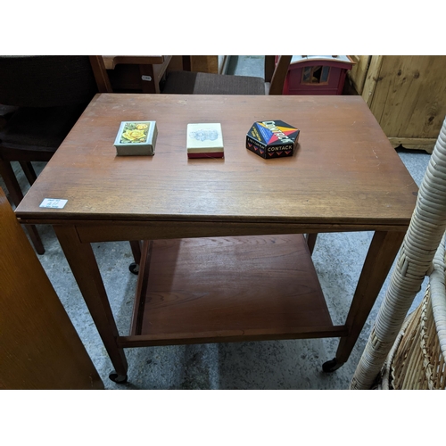 411 - A lightwood chest of four drawers, a teak card table with fold over swivel top, square tapering legs... 