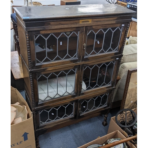 489 - A 1920's oak display cabinet having six glazed doors, barley twist legs and inscribed plaque, 130cm ... 