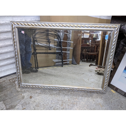 502 - A contemporary silver and gilt coloured wall mirror with gadroon decoration and rectangular bevelled... 