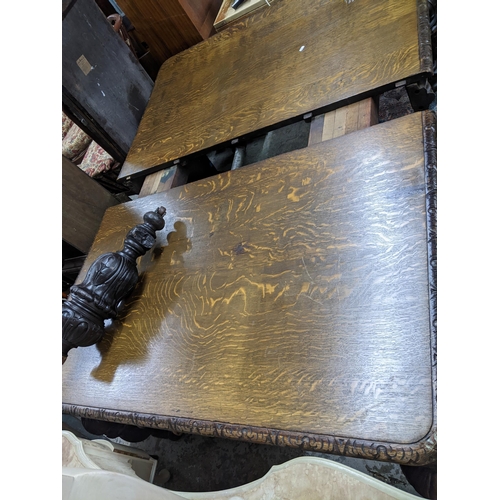 305 - A Victorian carved pussy oak wind-out extending dining table with two extra leaves, on heavily turne... 