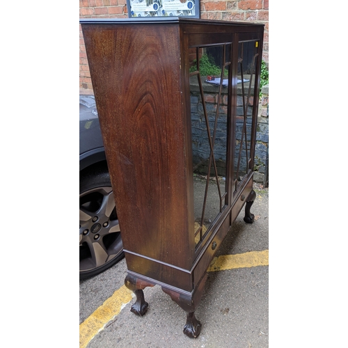 215 - A mahogany display cabinet with twin astragal doors, internal shelves, over two base drawers, on sho... 