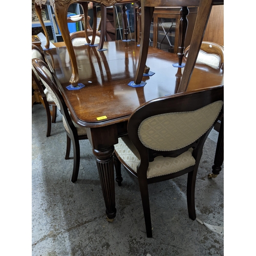 216 - A reproduction mahogany extending dining table on turned and fluted tapering legs and casters, 77cm ... 