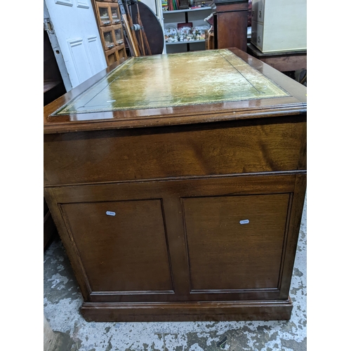 217 - An early 20th century mahogany twin pedestal writing desk the top with inset green tooled leather to... 