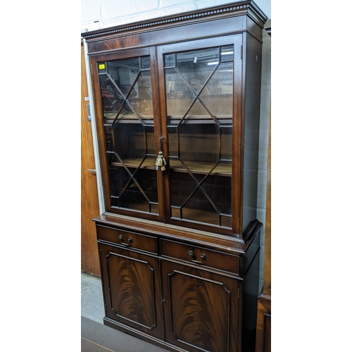 222 - Reproduction mahogany bookcase side cabinet, dental moulded cornice, above twin astragal glazed door... 