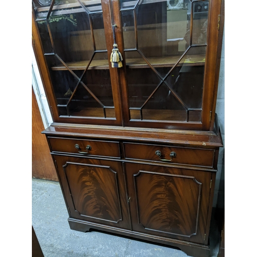 222 - Reproduction mahogany bookcase side cabinet, dental moulded cornice, above twin astragal glazed door... 