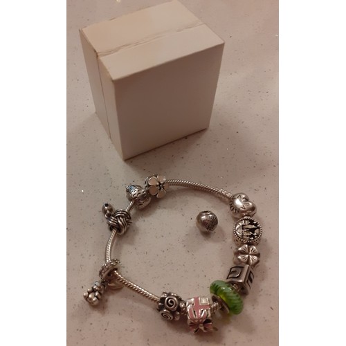 63 - A Pandora silver bracelet with 11 Pandora charms and one other together with branded box. Location:C... 