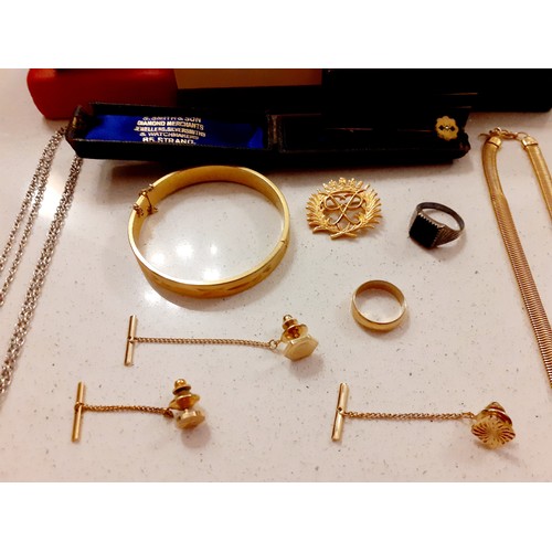 106 - A small quantity of jewellery to include an engraved gold tone bangle, a gold tone wedding band and ... 