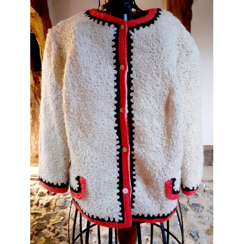 74 - A 1970's Derby Knit cream knitted jacket having an orange and black trim and a 5 cream button fasten... 