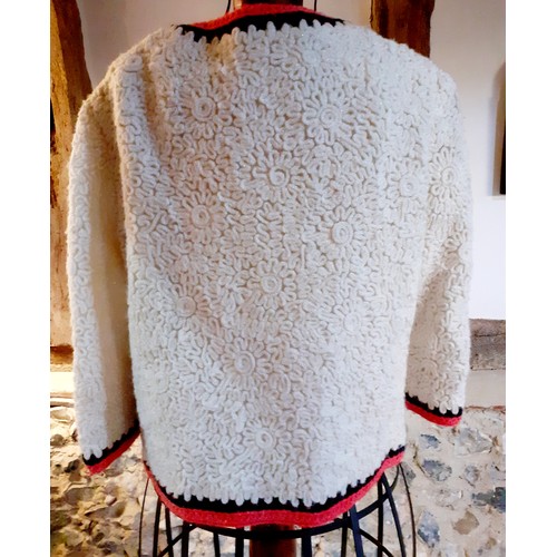 74 - A 1970's Derby Knit cream knitted jacket having an orange and black trim and a 5 cream button fasten... 