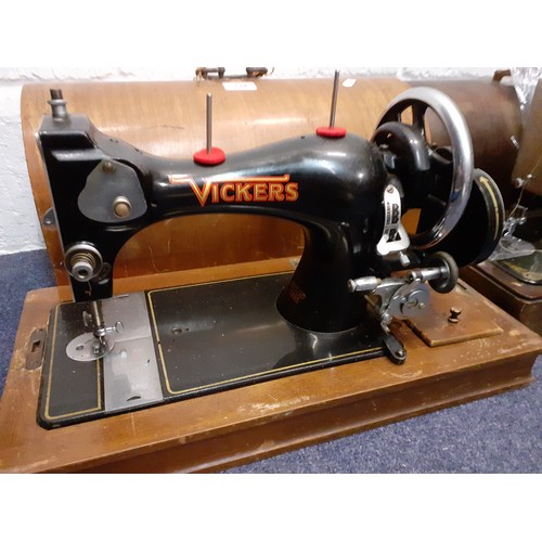 132 - Two vintage sewing machines comprising a Vickers machine Serial No:74832898 in an oak case with key,... 