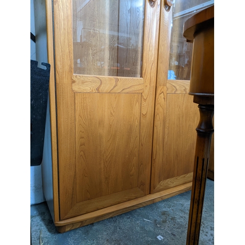 206 - An Ercol Windsor style full height display cabinet, three glass interior shelves and twin glazed dis... 