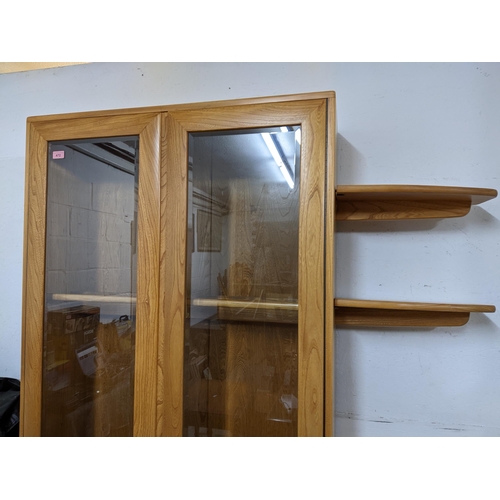 206 - An Ercol Windsor style full height display cabinet, three glass interior shelves and twin glazed dis... 