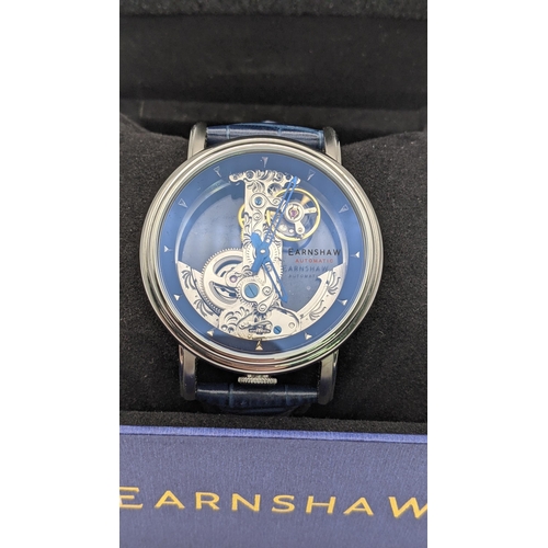 140 - An Earnshaw automatic stainless steel gents wristwatch with a clear face, visible movement, on a dar... 