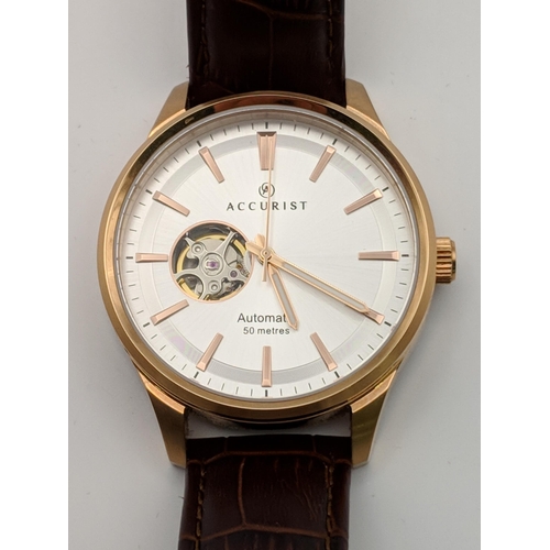 133 - An Accurist automatic gents stainless steel wristwatch with a silver coloured face with rose gold co... 