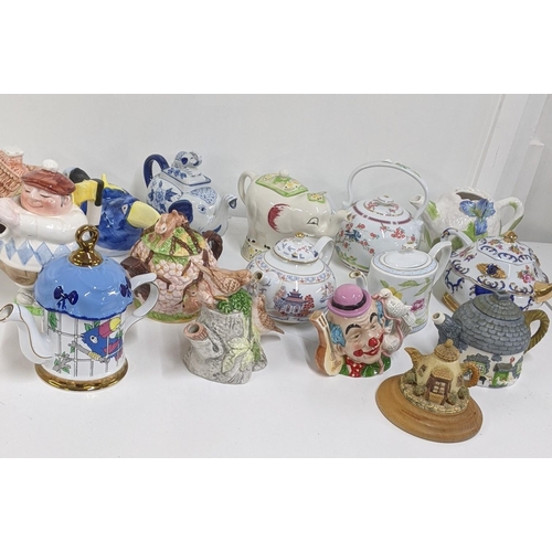 213 - A variety of ceramic teapots to include a teapot fashioned as a man playing golf, a clown and others... 