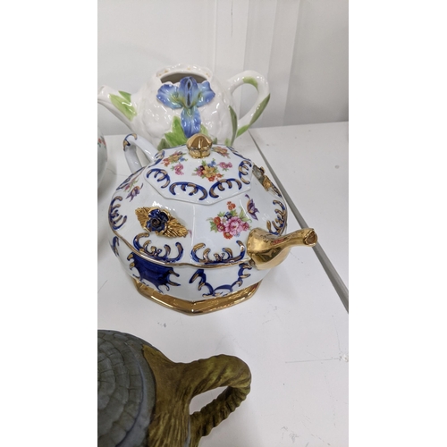 213 - A variety of ceramic teapots to include a teapot fashioned as a man playing golf, a clown and others... 