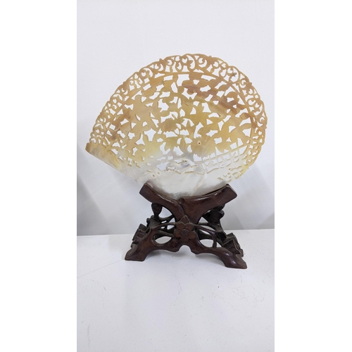 87 - A Chinese carved and pierced Mother of Pearl shell mounted on a stand 
Location:6.1