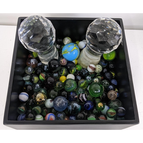 90 - A selection of various loose marbles together with a pair of crystal cut decanter stoppers, containe... 