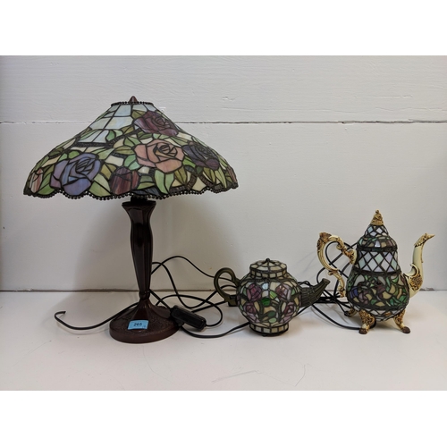 265 - Three Tiffany style lamps to include one fashioned as a teapot and a coffee pot (please not the plug... 