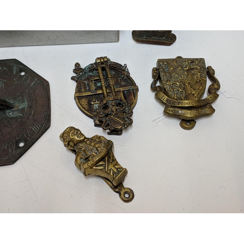 324 - Brass in include small door knockers and sundial, two framed 19th century boot plaques and a hat pin... 