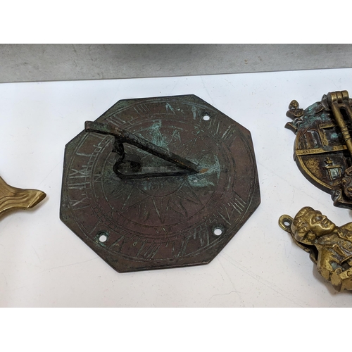 324 - Brass in include small door knockers and sundial, two framed 19th century boot plaques and a hat pin... 