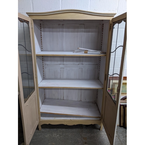 332 - A painted display cabinet with twin leaded display doors, three white painted adjustable shelves, on... 