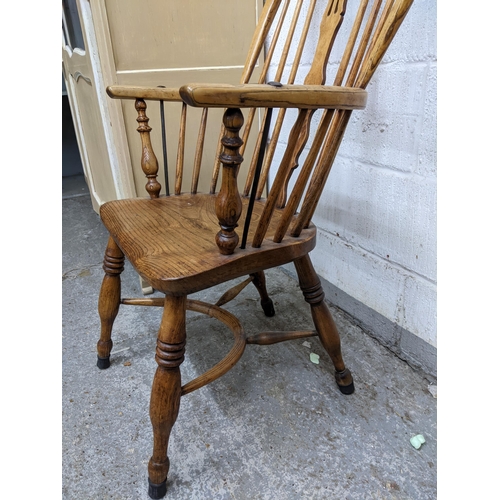 333 - A 19th century Windsor armchair with pierced centre splat, elm seat, ring turned legs united by a cr... 