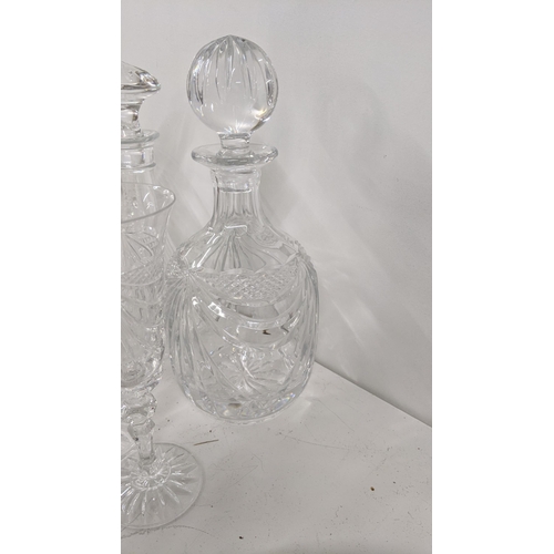 359 - A mixed lot to include crystal cut glassware to include two decanters, various drinking glasses alon... 