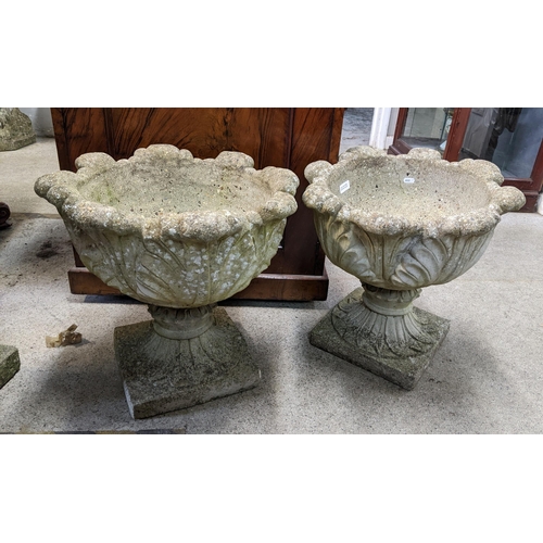 376 - A pair of reconstituted stoneware garden planters having moulded left decoration and on square bases... 