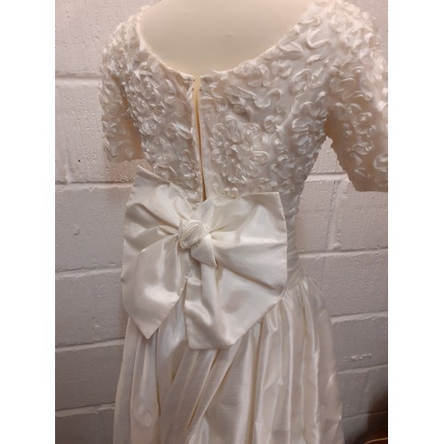 94 - A Donerica off white silk effect wedding dress having a zip fastening to the rear with large bow to ... 