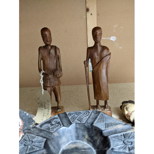 60 - A group of African tribal art carved wooden figures and a bowl to include a painted light wood fetis... 