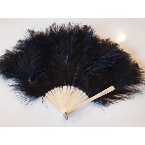 140 - An early 20th Century black ostrich feather 18 wand fan A/F, a 1930's glove envelope pouch containin... 