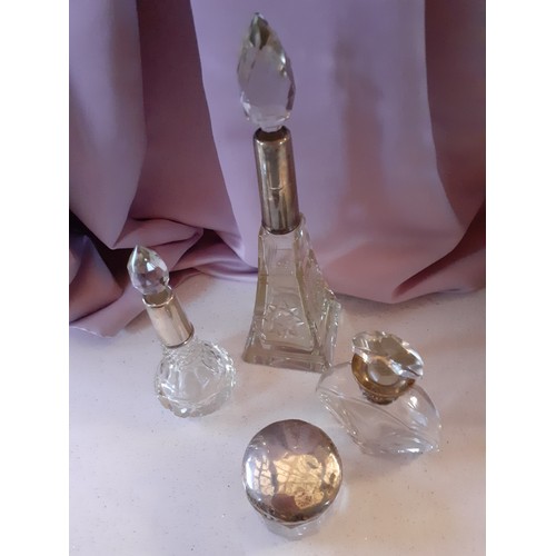 142 - Four early 20th Century glass dressing table bottles with silver collars and lid, various makers mar... 