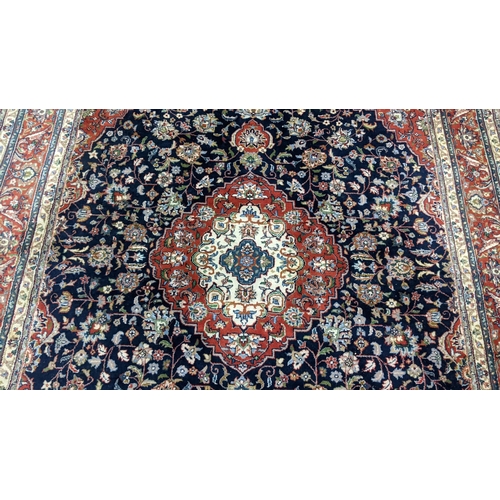 309 - A Persian Tabriz hand woven rug having a central medallion in a navette shaped field with floral des... 