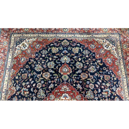 309 - A Persian Tabriz hand woven rug having a central medallion in a navette shaped field with floral des... 