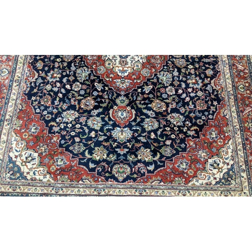 309 - A Persian Tabriz hand woven rug having a central medallion in a navette shaped field with floral des... 