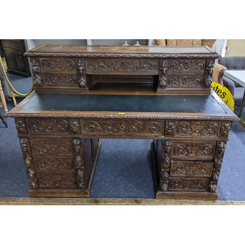 317 - A 19th century heavily carved oak twin pedestal desk having 14 drawers, half leather topped scriber ... 