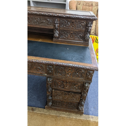 317 - A 19th century heavily carved oak twin pedestal desk having 14 drawers, half leather topped scriber ... 