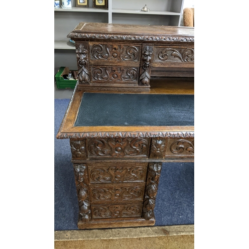 317 - A 19th century heavily carved oak twin pedestal desk having 14 drawers, half leather topped scriber ... 