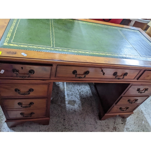 108 - A modern yew wood twin pedestal desk, gilt tooled green leather insert to top, central frieze drawer... 