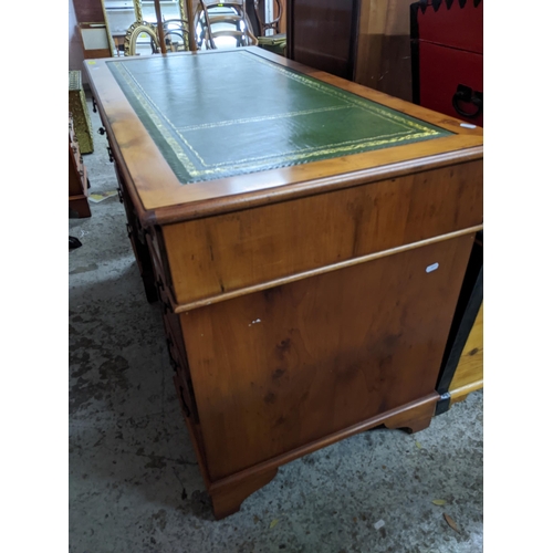 108 - A modern yew wood twin pedestal desk, gilt tooled green leather insert to top, central frieze drawer... 