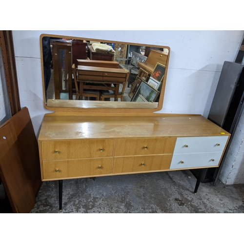 112 - A mid century Meredew dressing table, swing mirror, base with six drawers, two finished in white, on... 